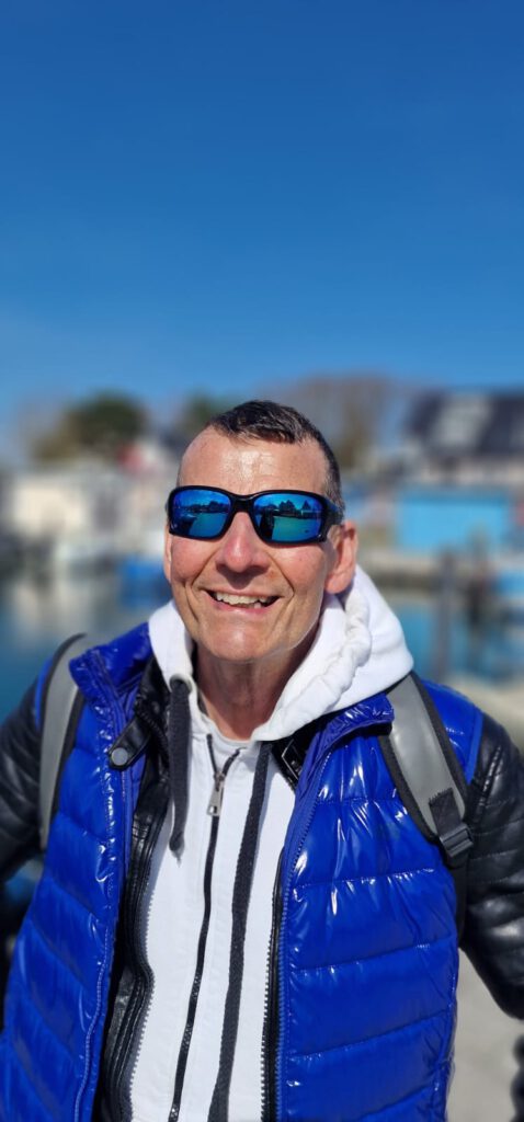 Klaus P. Portrait am Hafen mit blauer Weste