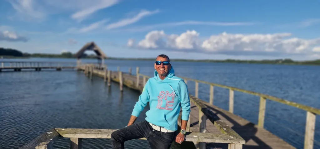 Klaus P. sitzend auf dem Ostsee-Steg mit Panorama