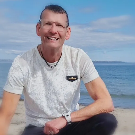 Klaus P. sitzend am Meer